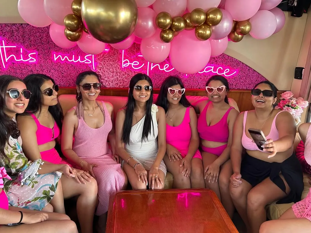 Bachelorette party aboard the Pink Panther with pink and gold balloons and a neon sign